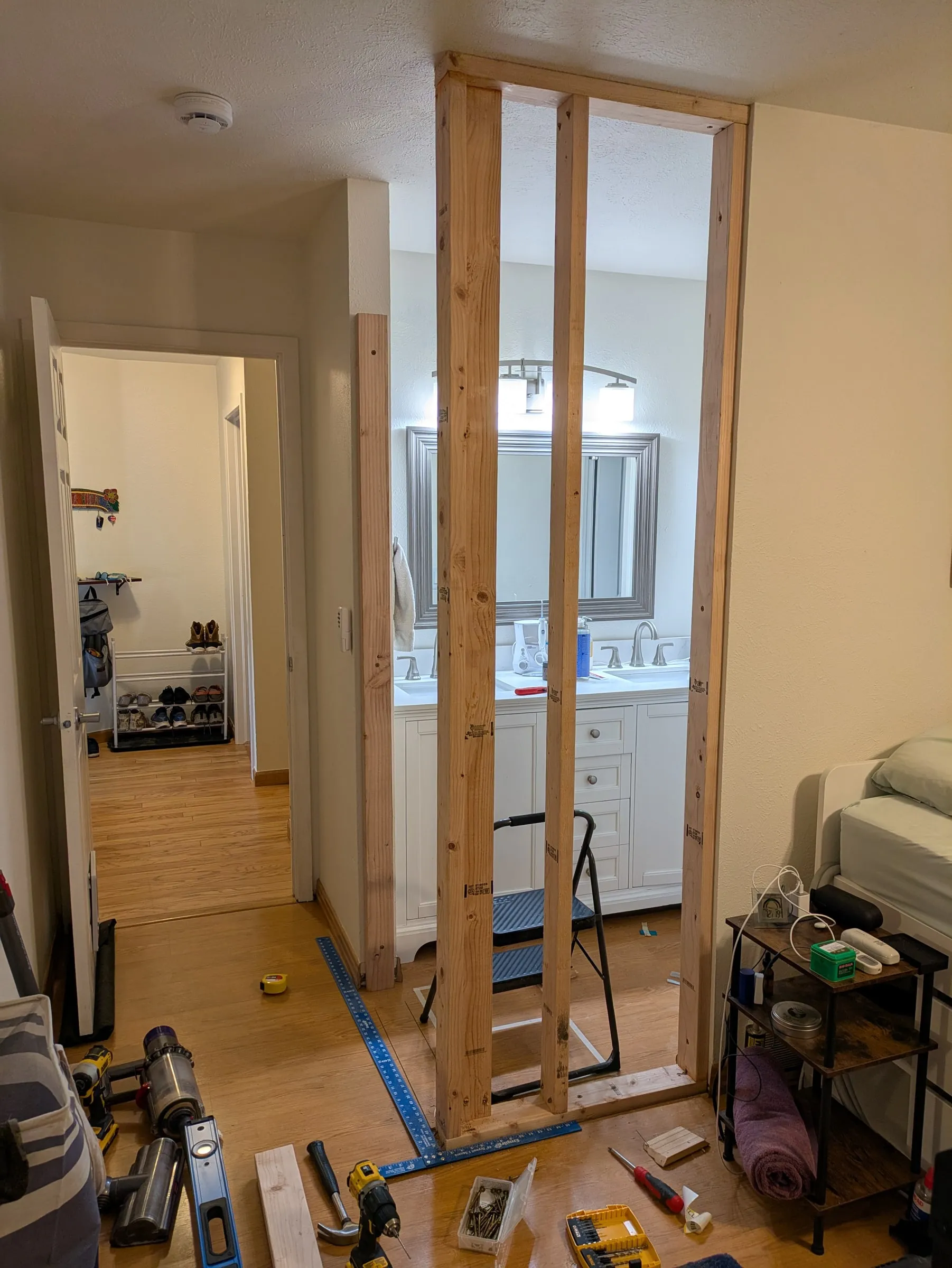 The new wall framed and standing, looking through into the bathroom