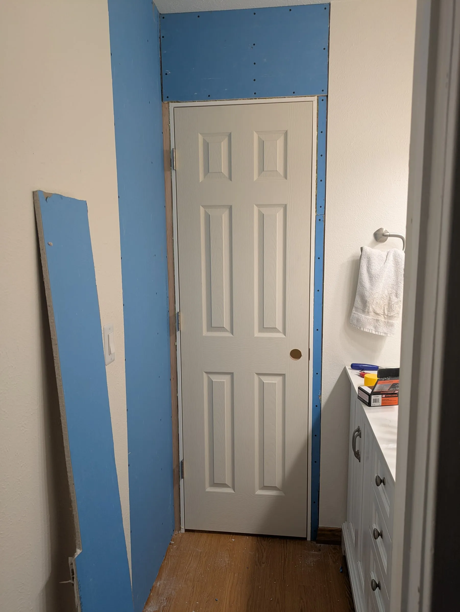 Drywall on the bathroom side, around the new door