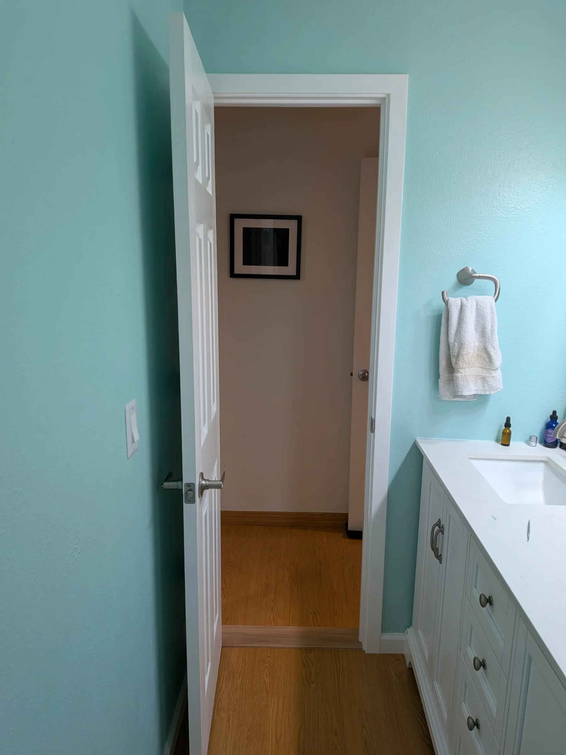 The same doorway from inside the bathroom, door open onto the bedroom