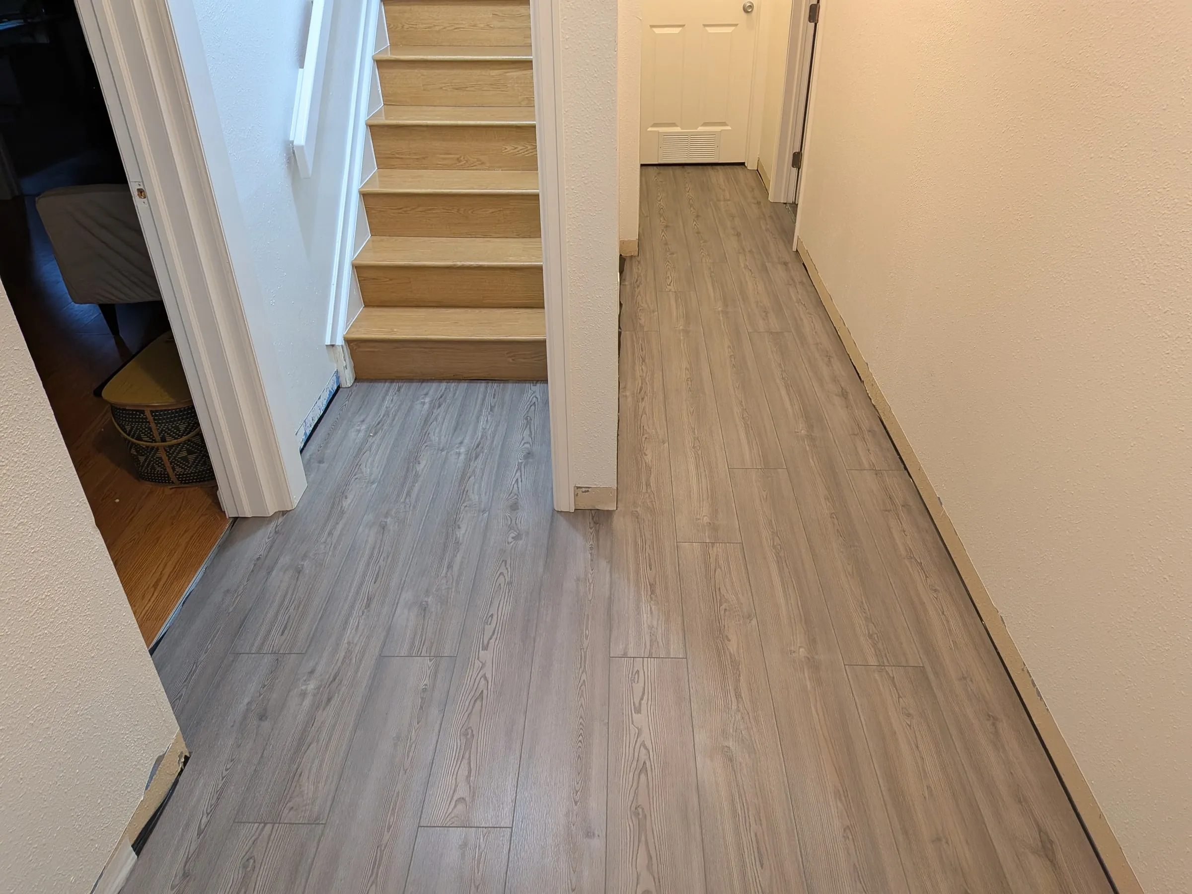 The hallway flooring fully in, before baseboards