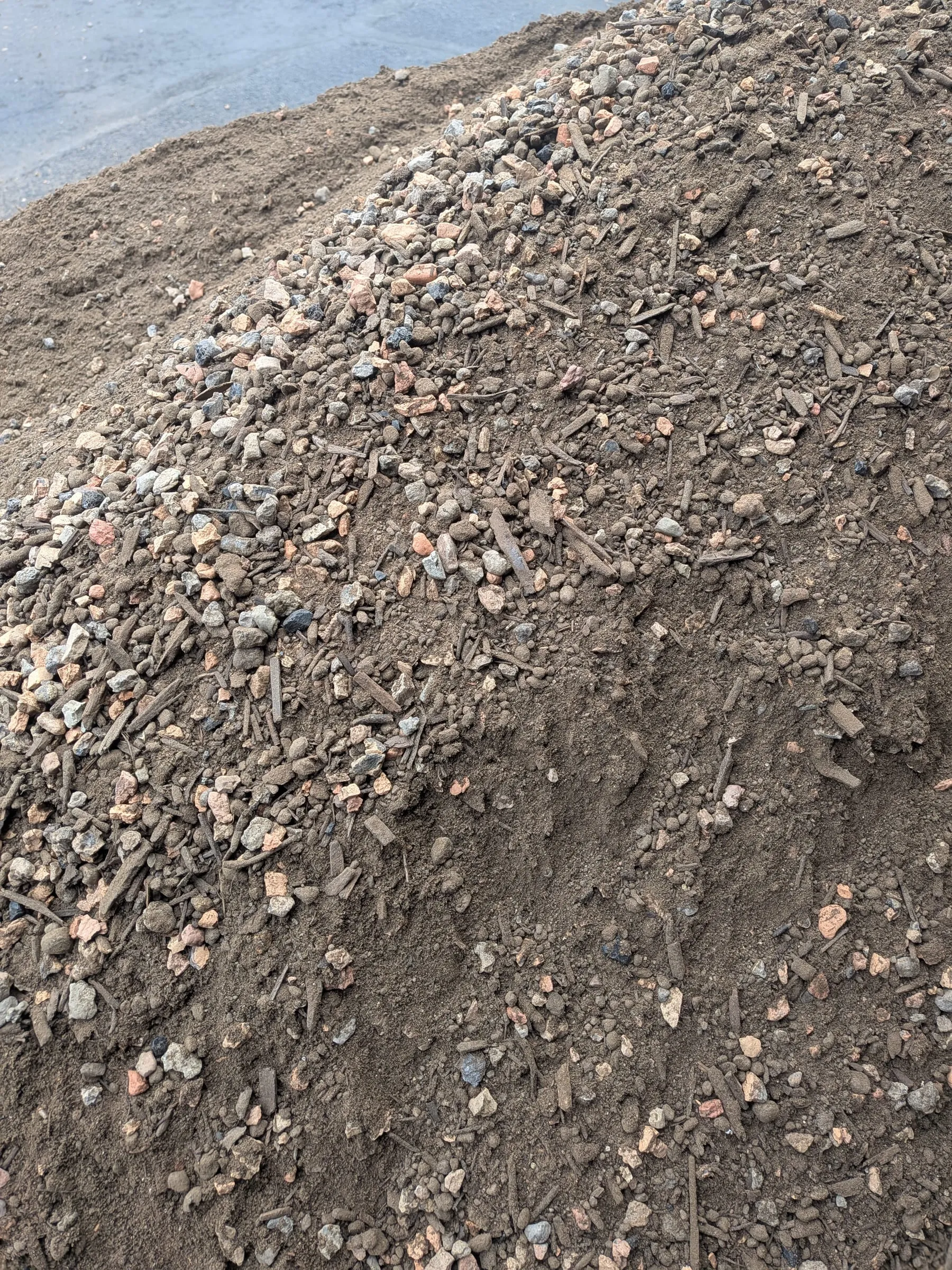 A close view of the delivered soil mix, showing pale angular shale, mixed gravel and dark fines